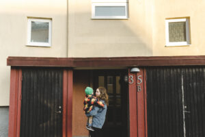 Förälder och barn utanför ett flerbostadshus